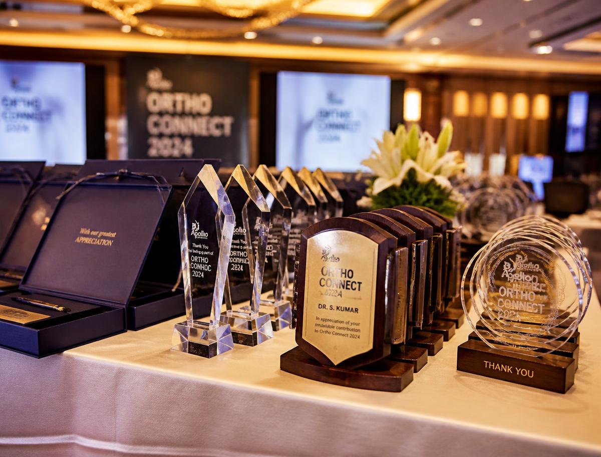Display table of crystal trophies, engraved plaques and premium gift boxes for conference faculty